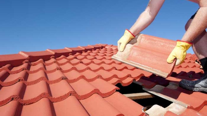 Construction worker tile roofing repair