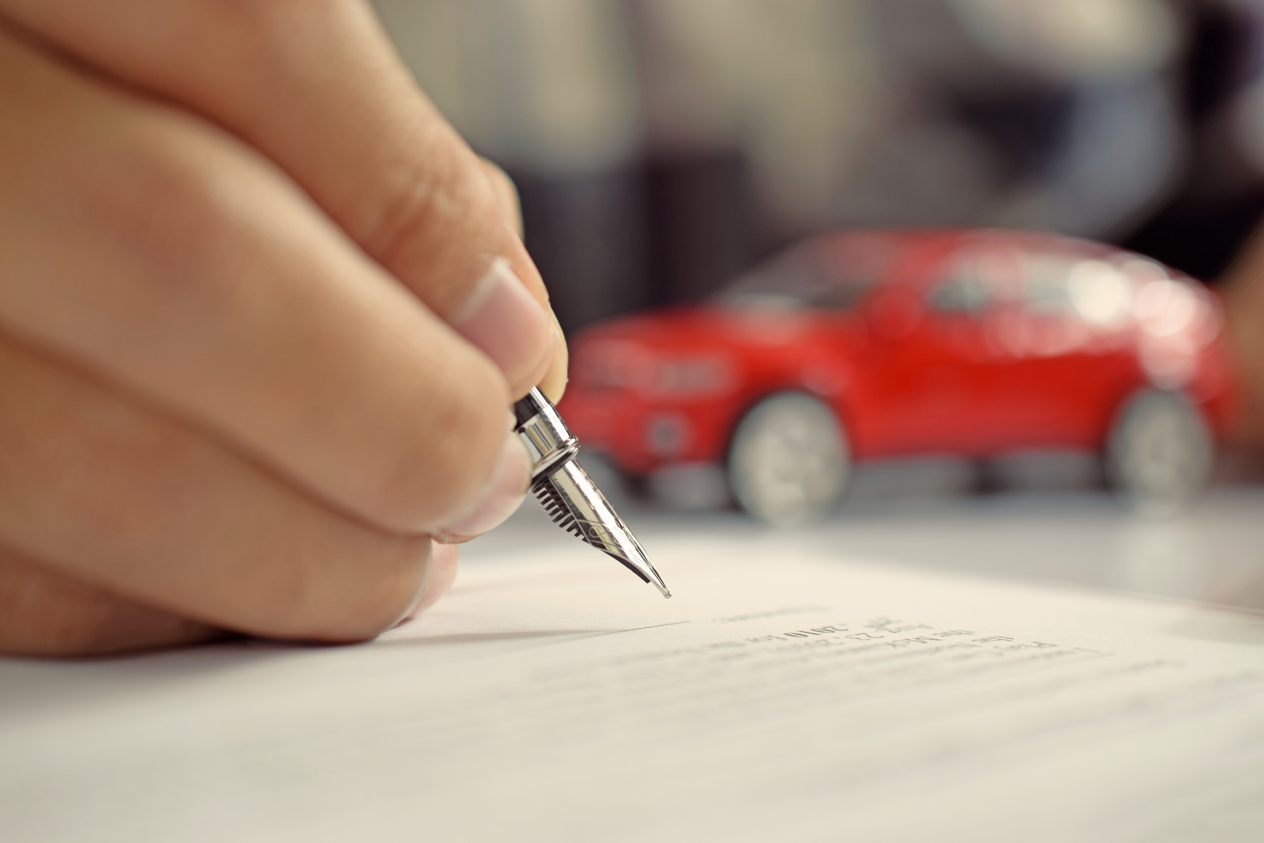 Man signing car insurance document. Writing signature on contrac